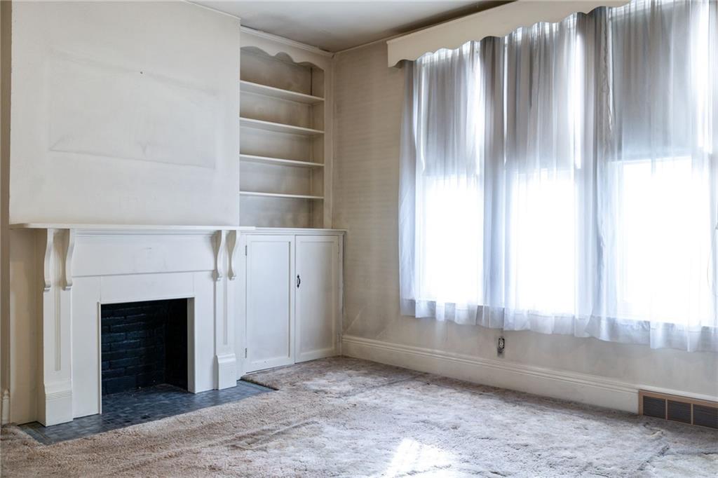 701 Beaver Street Sewickley, PA 15143 - Photo 9 of 39 a view of an empty room with a fireplace and window
