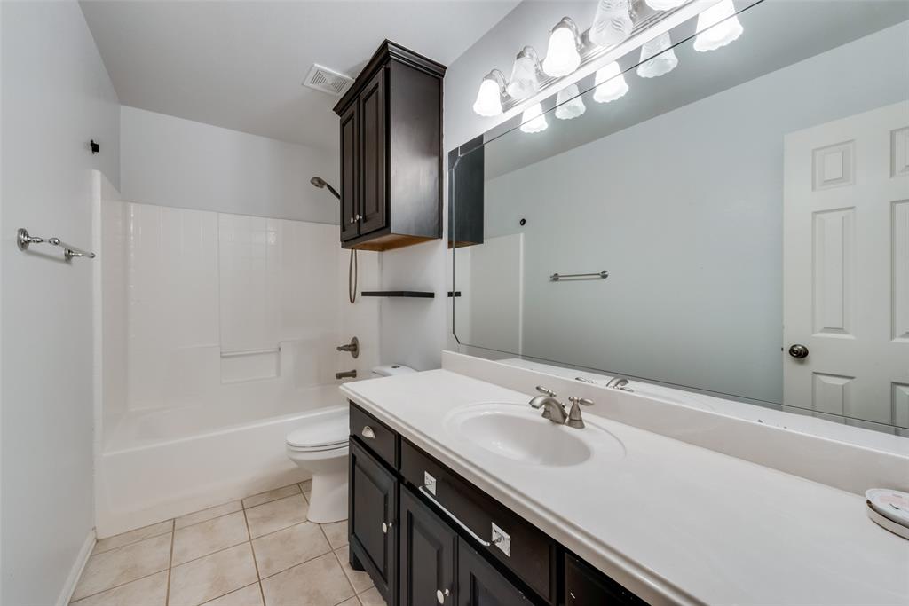 106 South 3rd Avenue Mansfield, TX 76063 - Photo 18 of 30 a bathroom with a sink a toilet and mirror
