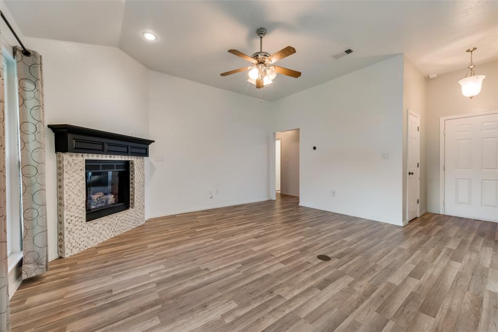 106 South 3rd Avenue Mansfield, TX 76063 - Photo 4 of 30 a view of an empty room with wooden floor and a fireplace