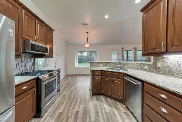 a kitchen with granite countertop wooden cabinets and a stainless steel appliances