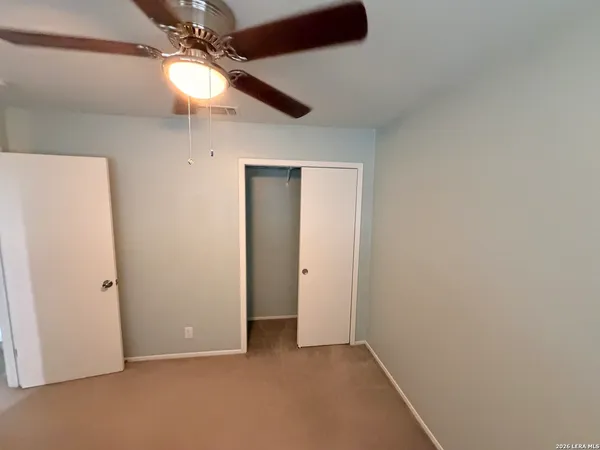 an empty room with a fan and a fan