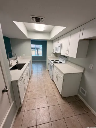 a kitchen with a sink a stove and cabinets