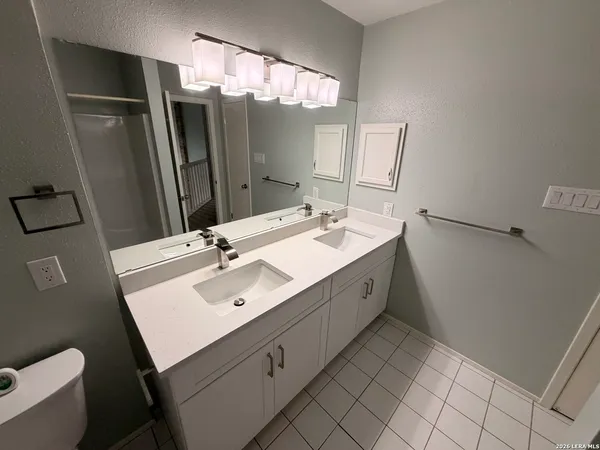 a bathroom with a double vanity sink mirror and toilet