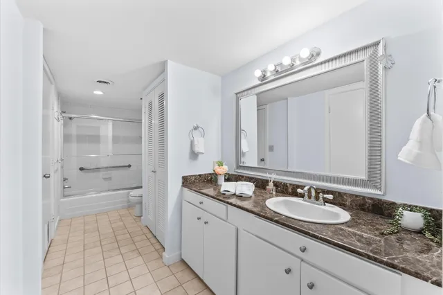 a spacious bathroom with a granite countertop sink a mirror and a bathtub
