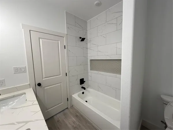 a bathroom with a bathtub a toilet and a shower