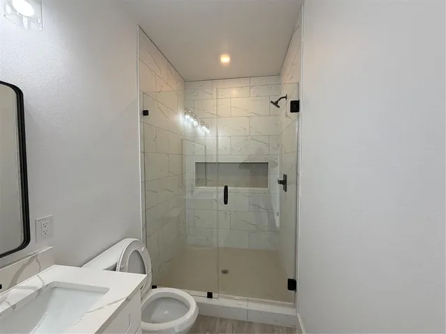 a bathroom with a sink toilet and shower