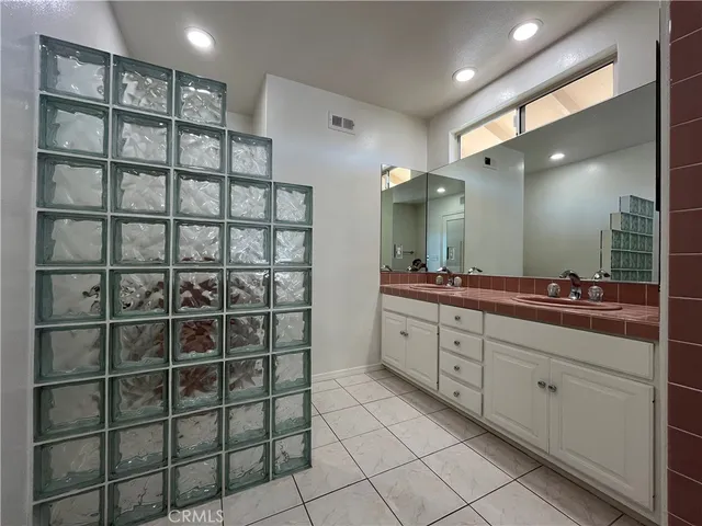 an empty room with chandelier fan and fireplace
