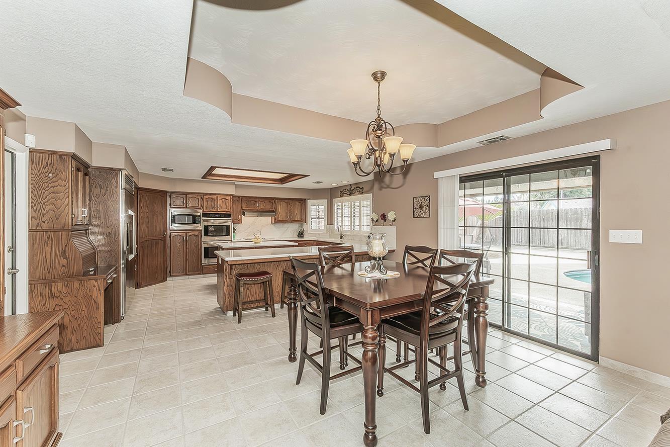 1405 West Flora Avenue Reedley, CA 93654 - Photo 14 of 61 a view of a dining room with furniture and a chandelier