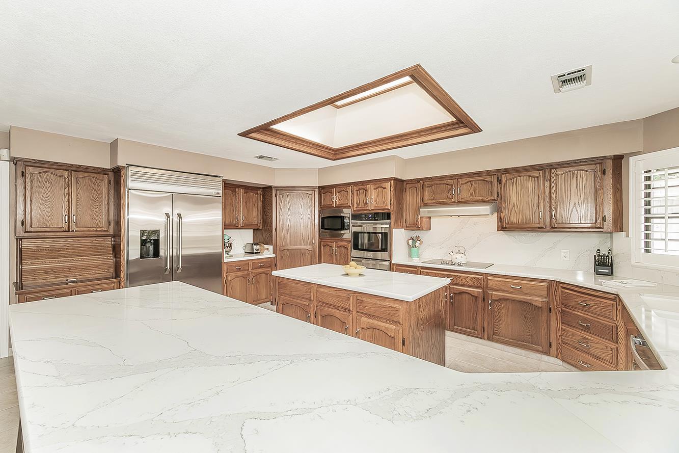 1405 West Flora Avenue Reedley, CA 93654 - Photo 19 of 61 a large white kitchen with stainless steel appliances kitchen island granite countertop a sink and cabinets