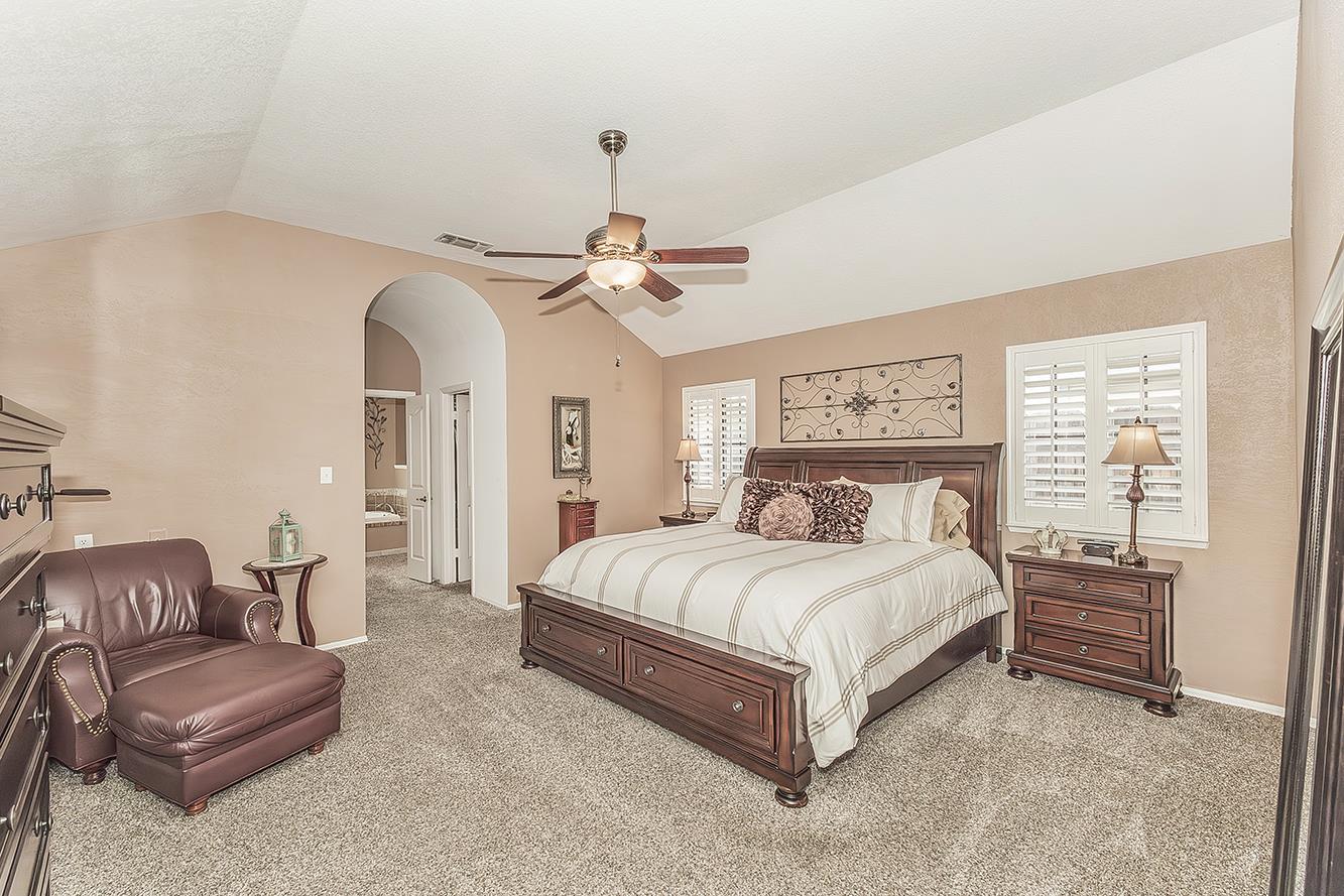 1405 West Flora Avenue Reedley, CA 93654 - Photo 23 of 61 a spacious bedroom with a bed couch chandelier and a window