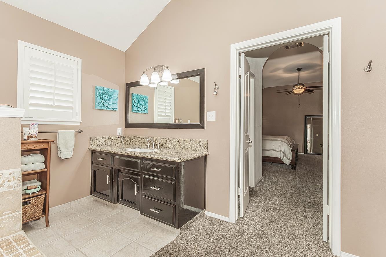 1405 West Flora Avenue Reedley, CA 93654 - Photo 30 of 61 a en suite bathroom with a granite countertop sink and a mirror