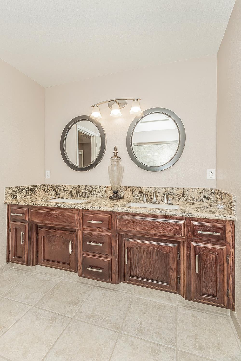 1405 West Flora Avenue Reedley, CA 93654 - Photo 35 of 61 a bathroom with a granite countertop sink and a mirror
