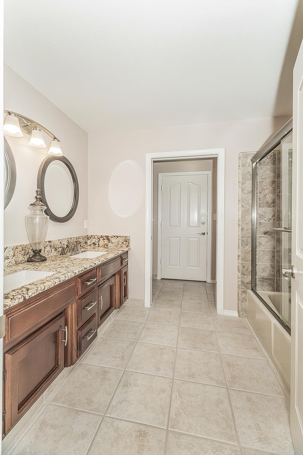 1405 West Flora Avenue Reedley, CA 93654 - Photo 37 of 61 a spacious bathroom with a granite countertop sink a mirror and a vanity