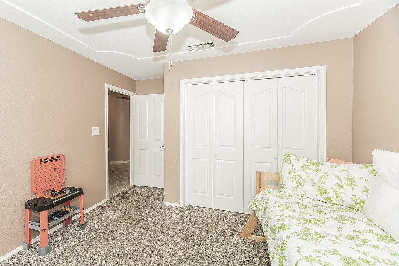 1405 West Flora Avenue Reedley, CA 93654 - Photo 40 of 61 a bedroom with a bed and a chandelier