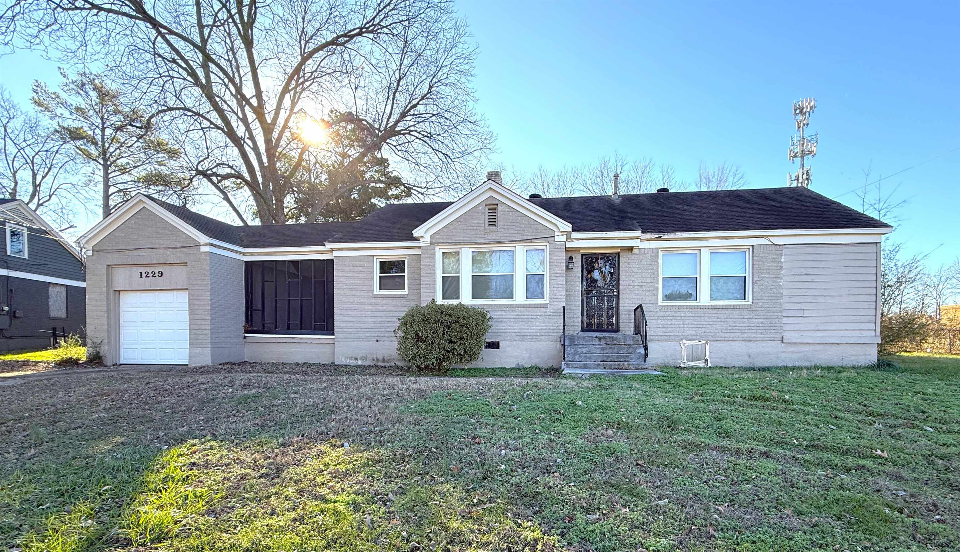 Ranch-style home with brick siding, a front lawn, an attached garage, and crawl space