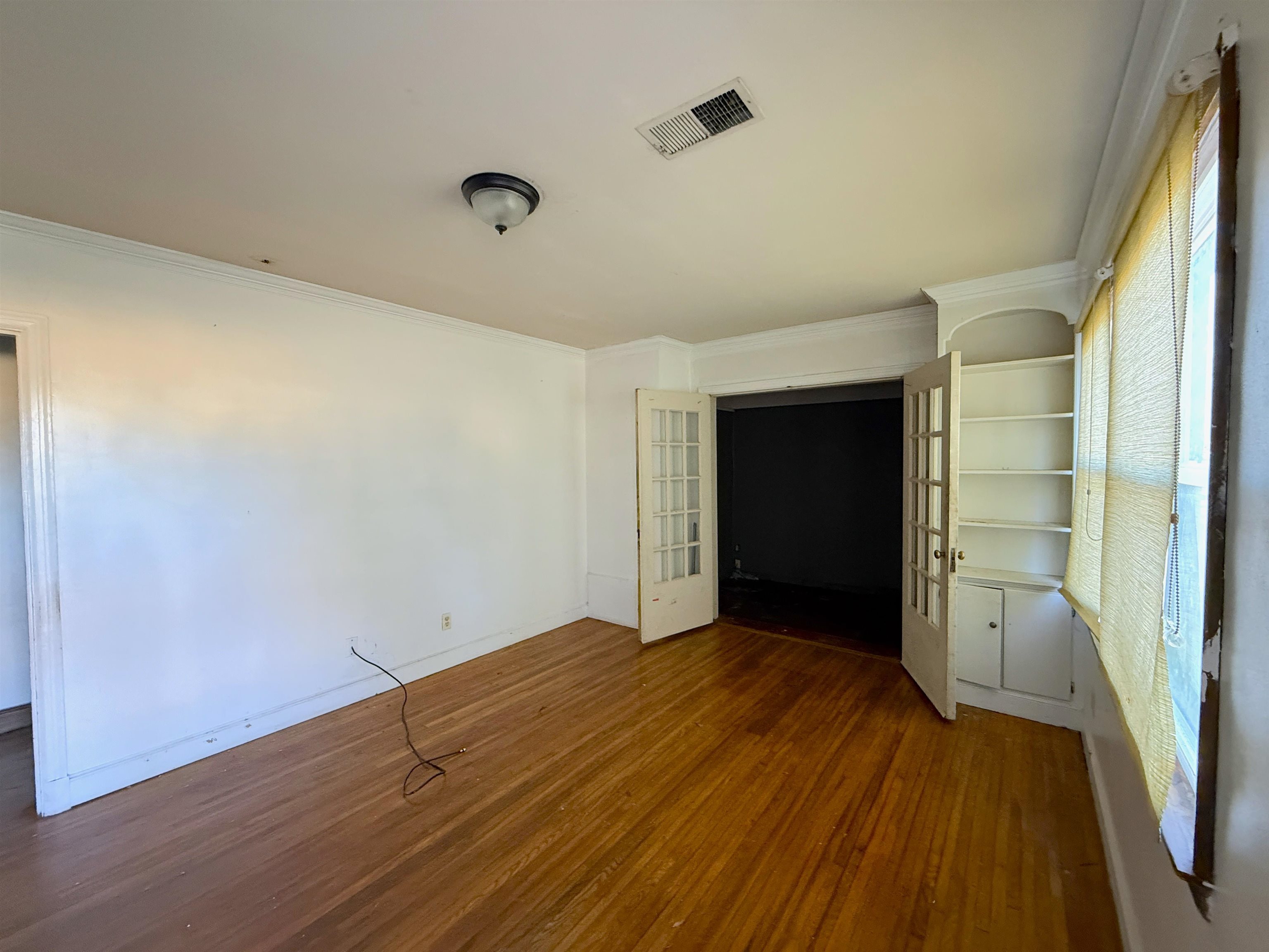 1229 Marlin Road Memphis, TN 38116 - Photo 16 of 20 Unfurnished bedroom featuring french doors, dark wood-type flooring, and ornamental molding