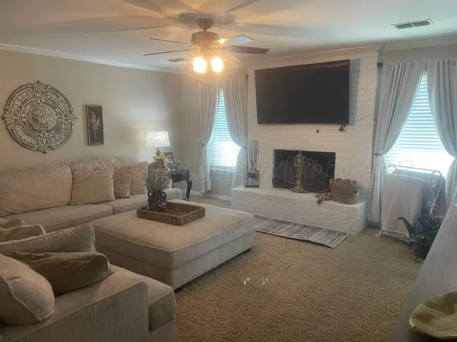 a living room with furniture a fireplace and a flat screen tv