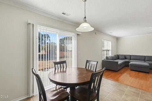 a living room with furniture a chandelier and a dining table