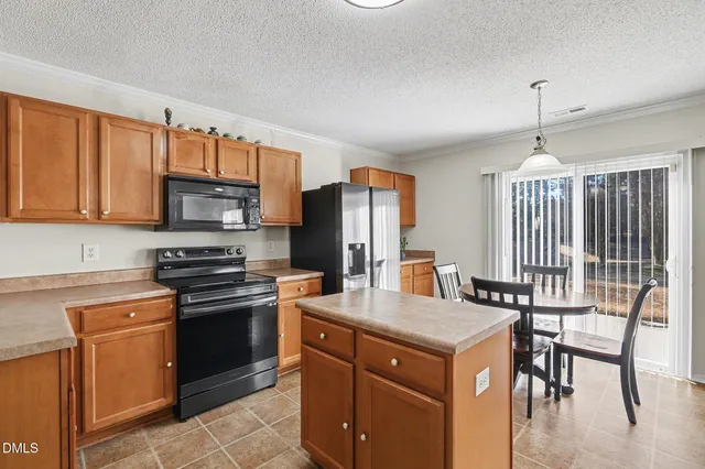 a kitchen with a stove a sink a table and chairs