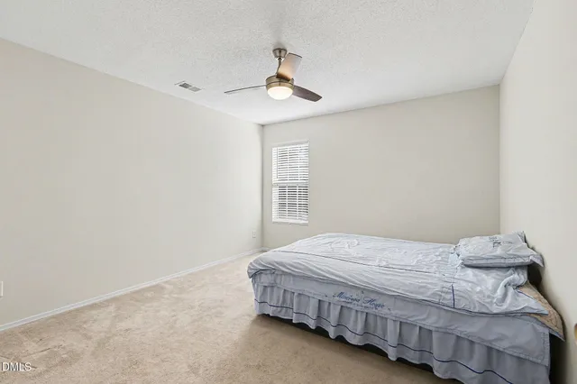 a bedroom with a bed and a ceiling fan