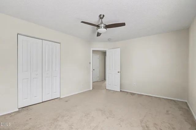 an empty room with a window and a ceiling fan
