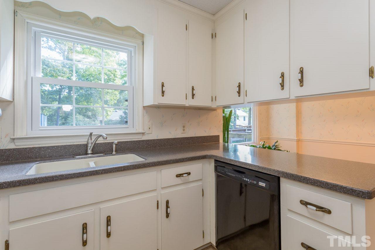 7324 Mill Ridge Road Raleigh, NC 27613 - Photo 17 of 24 a kitchen with granite countertop a sink white cabinets and a window