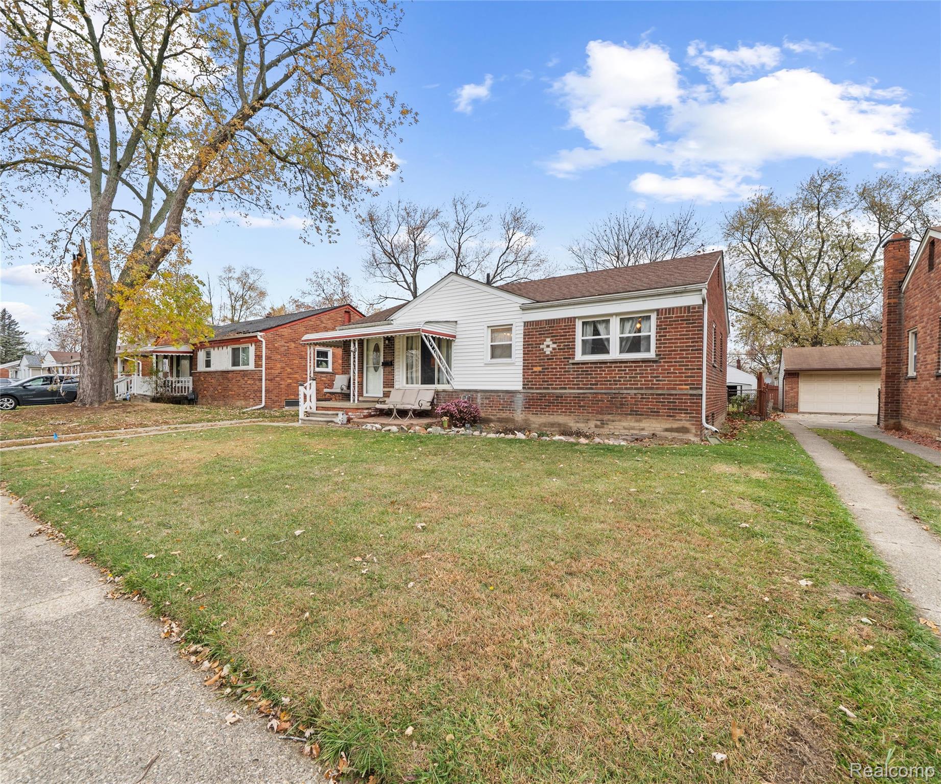28940 Grandview Street Inkster, MI 48141 - Photo 2 of 41 View of front of house with brick siding, a front lawn, a garage, and an outdoor structure