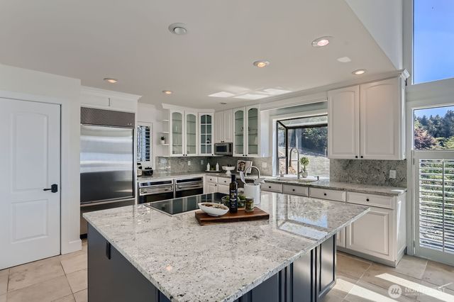 a kitchen with kitchen island sink stove and refrigerator