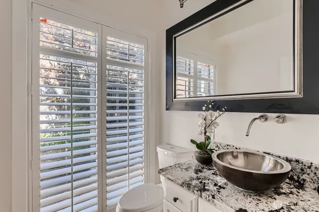a bathroom with a granite countertop sink and a mirror