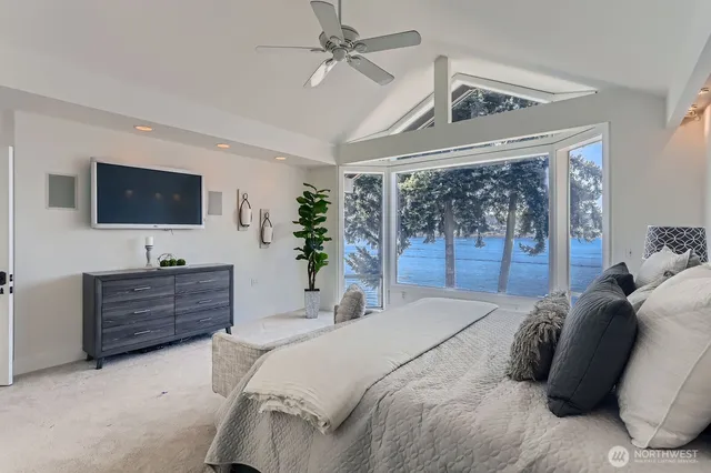 a bed room with a bed a television and a large window