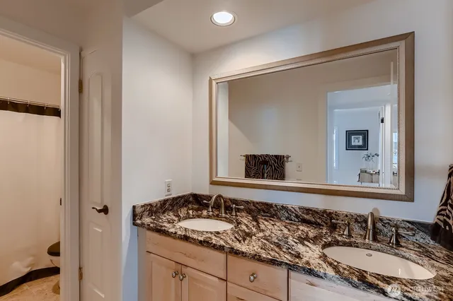 a bathroom with a granite countertop sink and a mirror