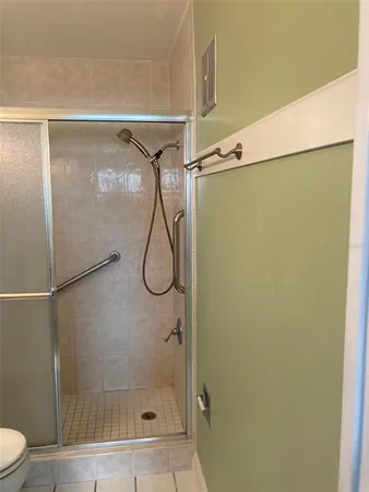 a bathroom with a granite countertop sink a toilet a mirror and shower
