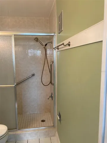 a bathroom with a granite countertop sink a toilet a mirror and shower