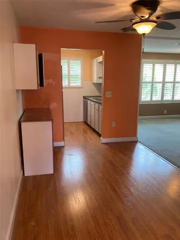 a view of a kitchen with wooden floor and electronic appliances
