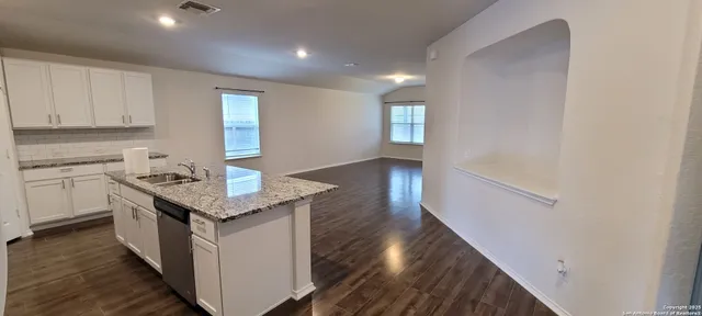 a view of a kitchen with wooden floor and a window
