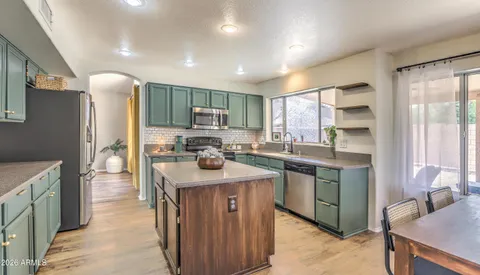 a kitchen with stainless steel appliances granite countertop sink stove refrigerator and cabinets