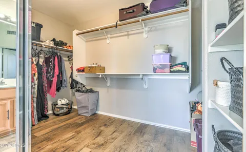 a view of walk in closet with clothes and shoes