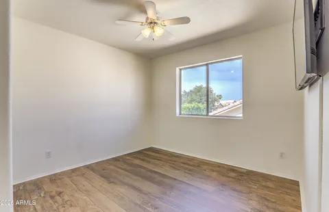 an empty room with a window and ceiling fan
