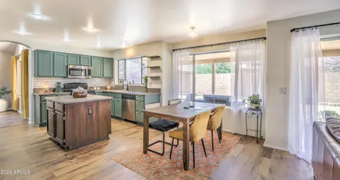 a kitchen with a table chairs refrigerator and cabinets