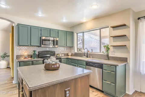 a kitchen with a sink a window and chairs