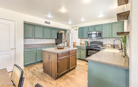 a kitchen with kitchen island a sink stove and refrigerator