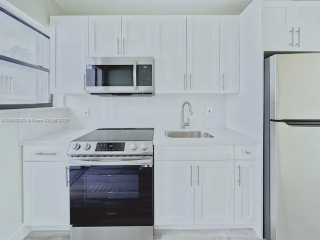 a kitchen with stainless steel appliances granite countertop a stove a microwave and a refrigerator