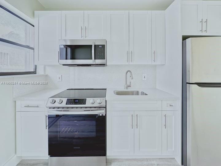 1010 Opa-locka Boulevard, Unit 2 Opa-Locka, FL 33054 - Photo 12 of 13 a kitchen with stainless steel appliances granite countertop a stove a microwave and a refrigerator