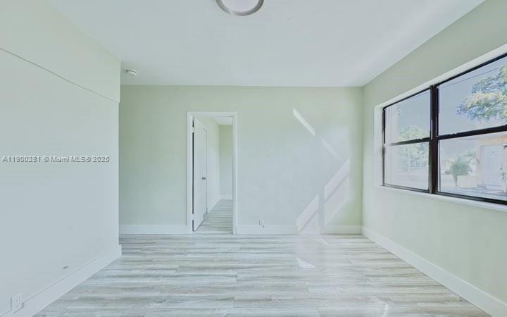 1010 Opa-locka Boulevard, Unit 2 Opa-Locka, FL 33054 - Photo 4 of 13 a view of an empty room with wooden floor and windows