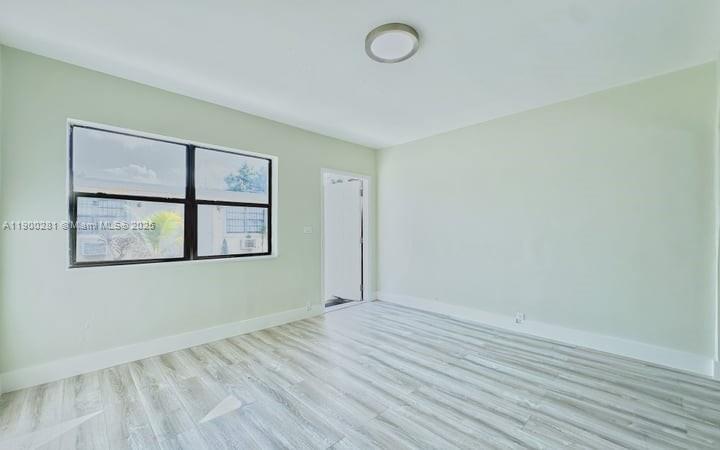 1010 Opa-locka Boulevard, Unit 2 Opa-Locka, FL 33054 - Photo 5 of 13 an empty room with wooden floor and window
