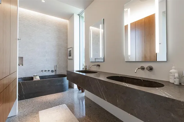 a bathroom with a bathtub sink and mirror