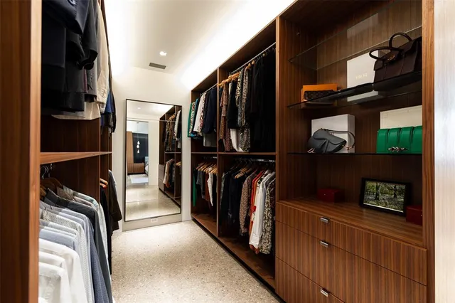 a view of walk in closet with clothes and shoes