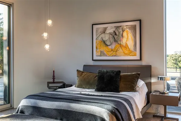 a bedroom with a bed and painting on the wall