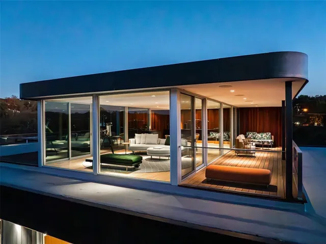 a view of a patio with table and chairs potted plants with floor to ceiling window