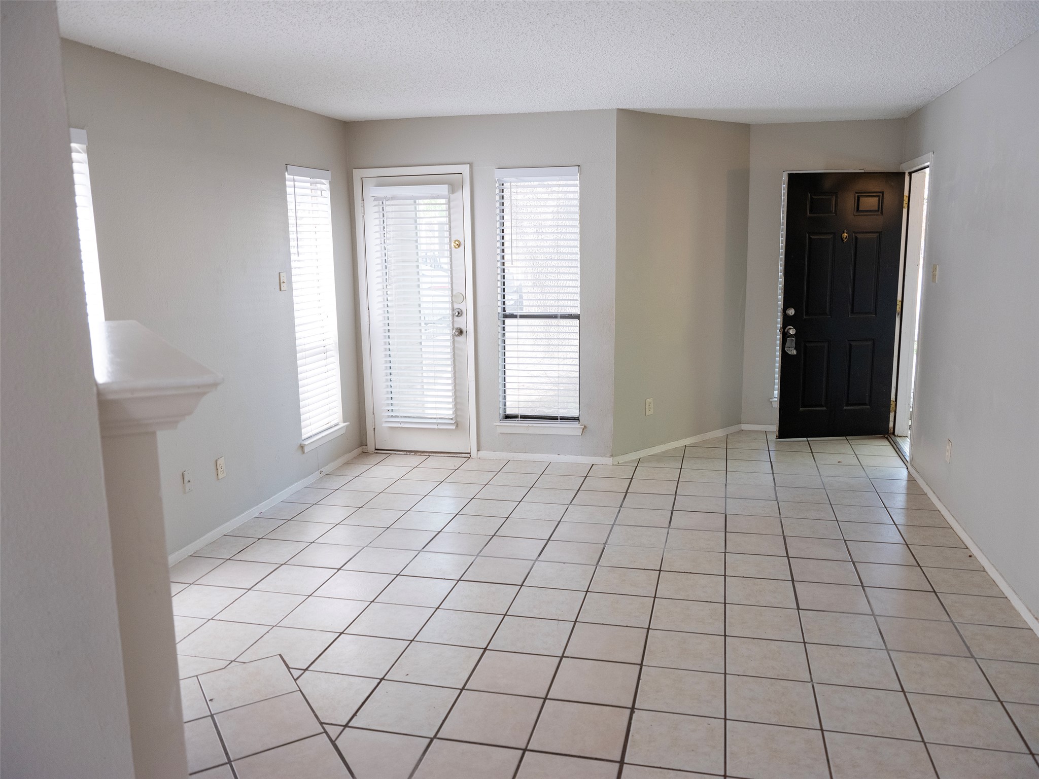 1903 West Loop, Unit B Austin, TX 78758 - Photo 6 of 15 Foyer with baseboards, light tile patterned floors, and a textured ceiling